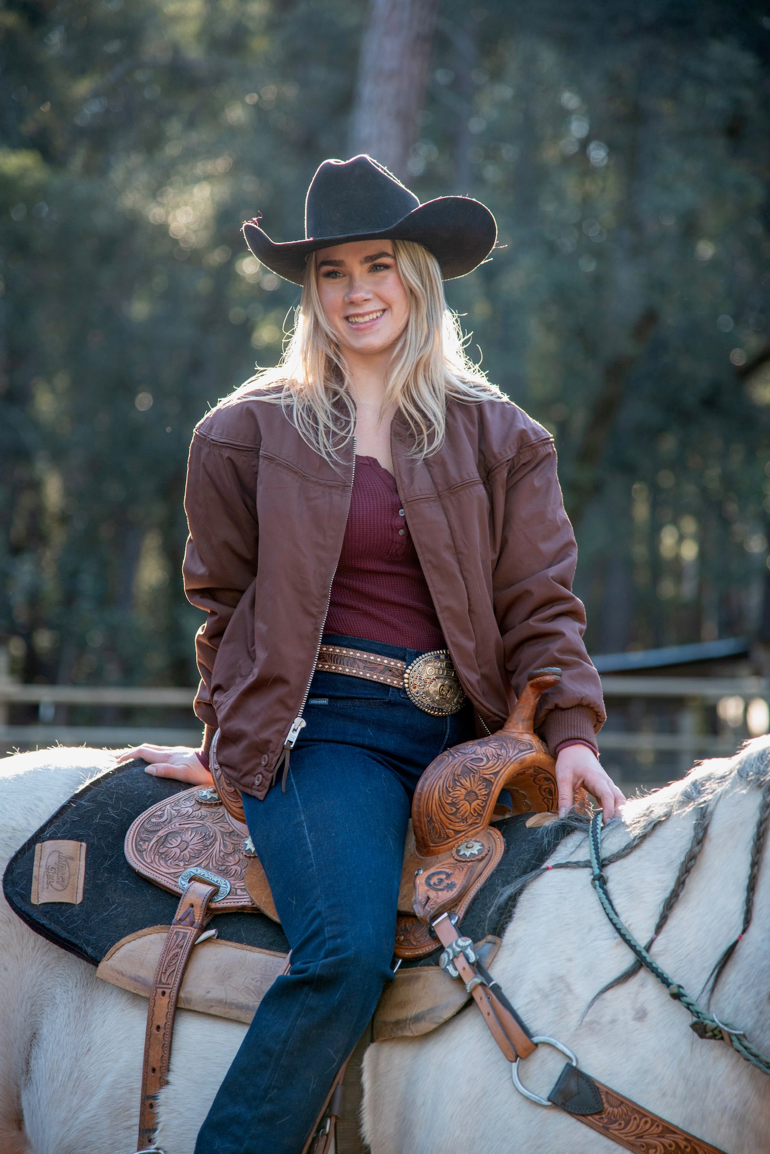 GIRL ON TOP OF HORSE WEARING A CHOCOLATE BROWN JACKET 