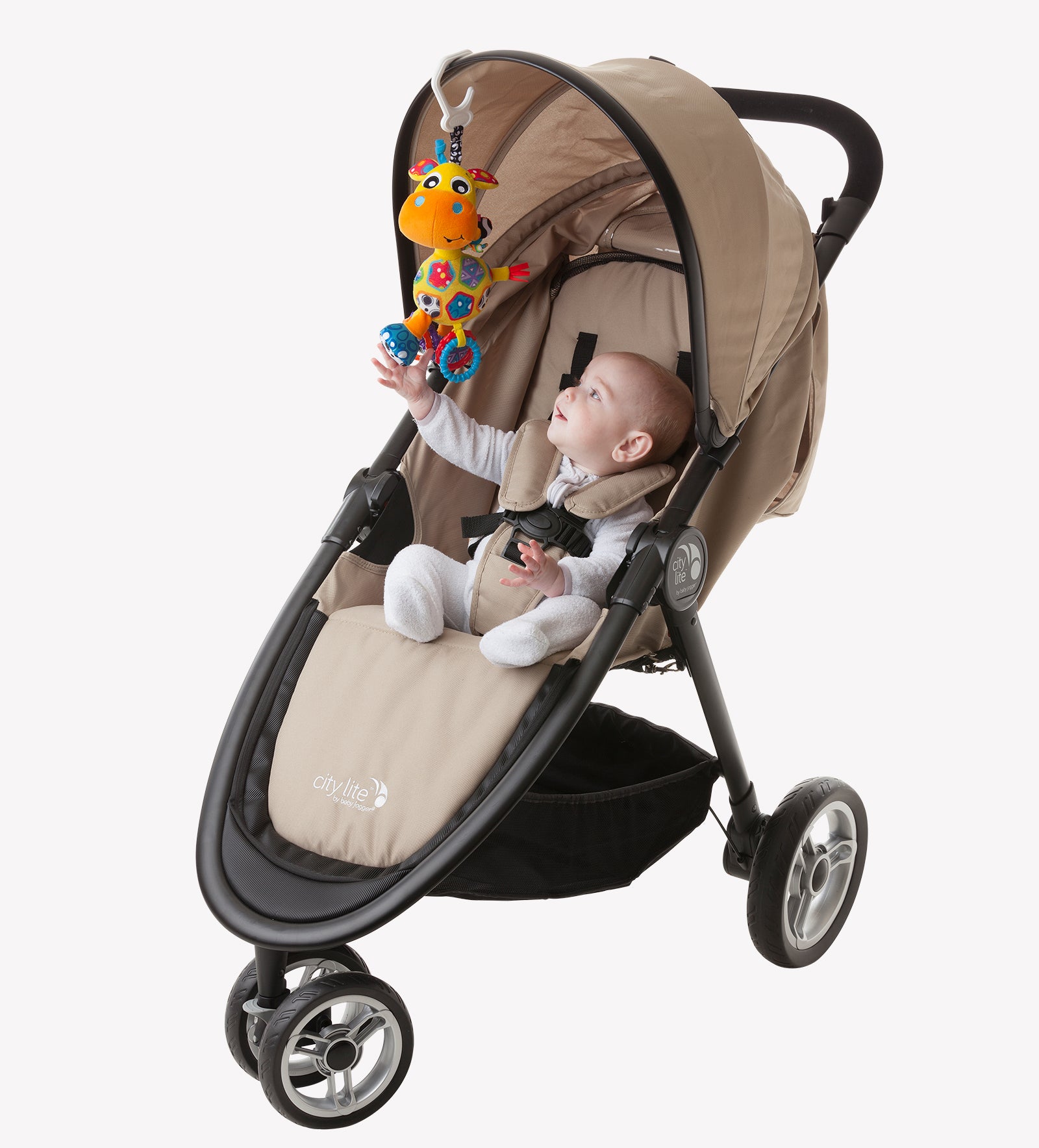 A baby in a stroller trying to reach Playgro Giraffe Stroller toys hanging in  the stroller canopy