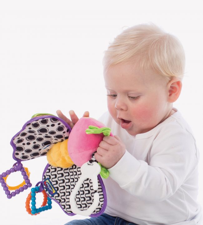 A baby boy play with a teether activity baby toy