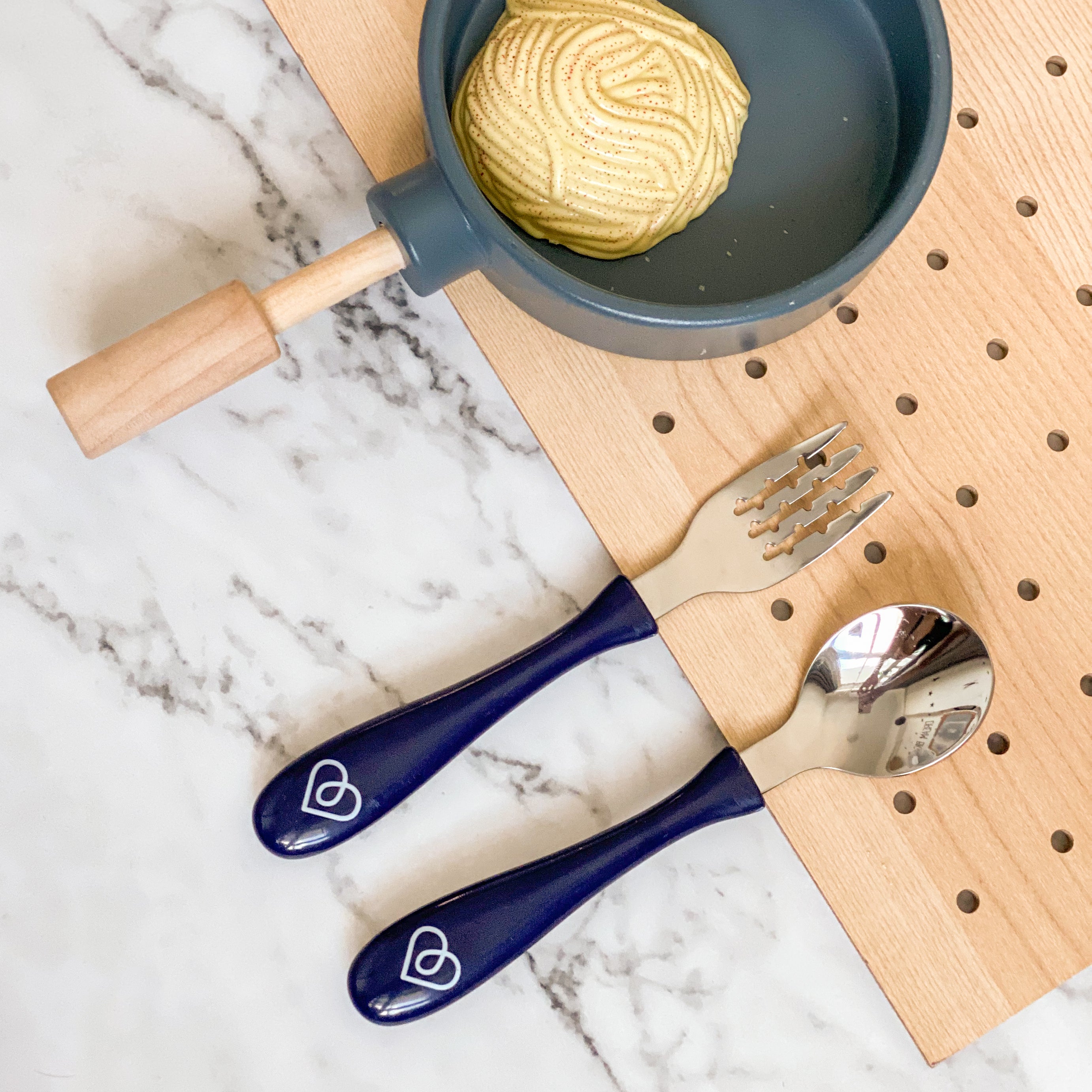 LoveAmme travel cutlery set displayed with pasta and chopping board