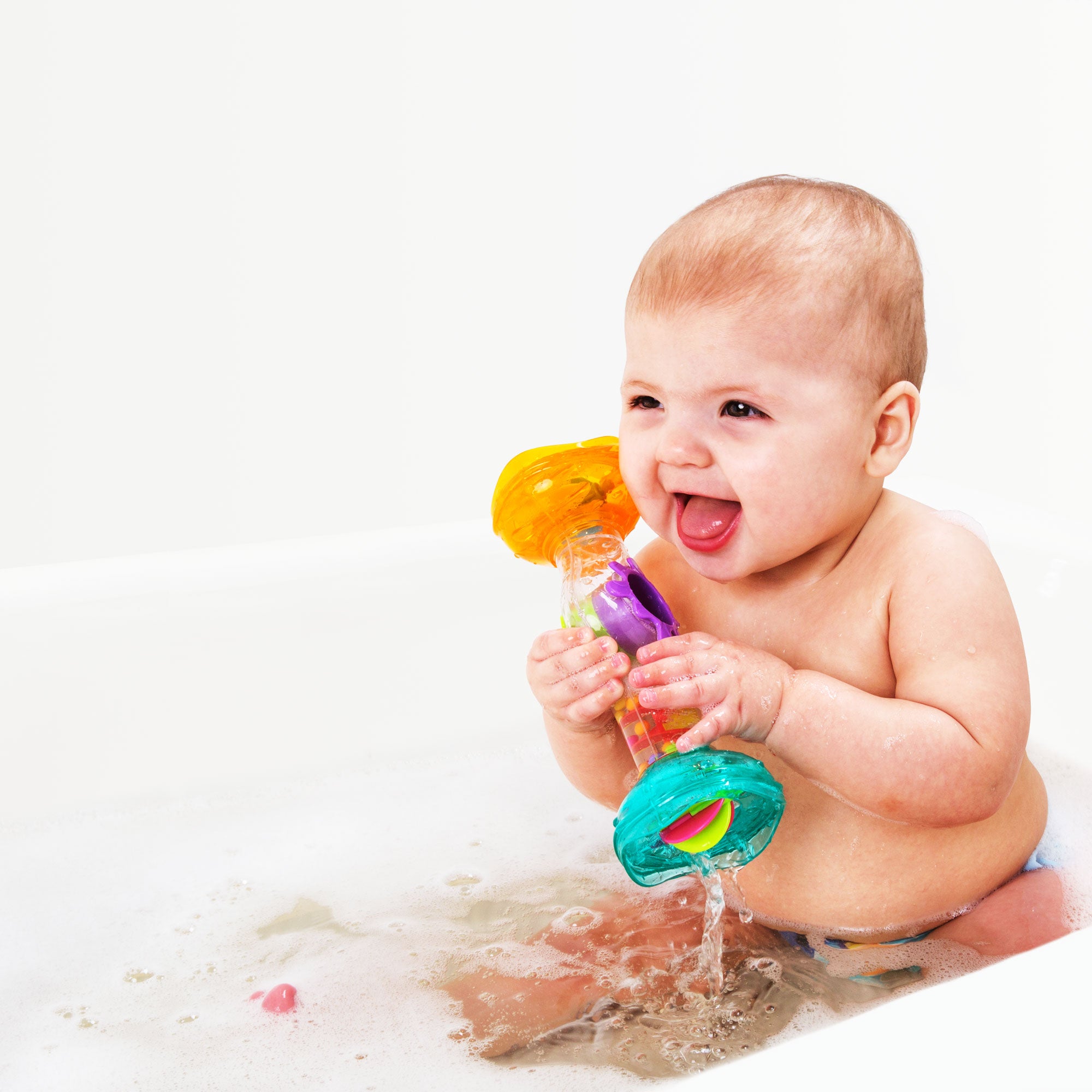 A baby boy playing Playgro rainmaker toy in the bath tub