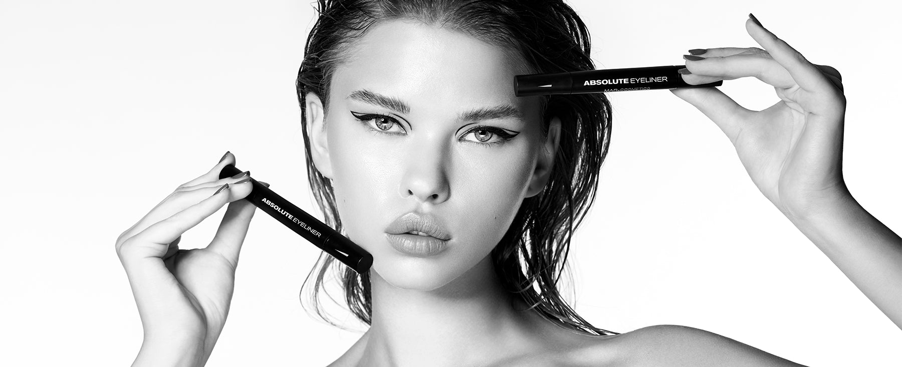 Banner Modelo MarCosmetics viendo al frente sosteniendo dos Absolute Eyeliner, foto en blanco y negro