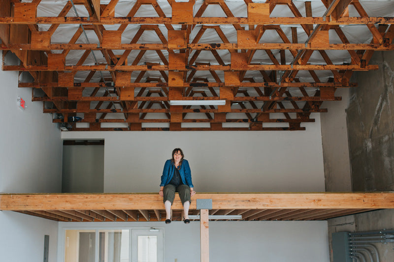 Betsy Cross sitting on the loft in the new betsy & iya space