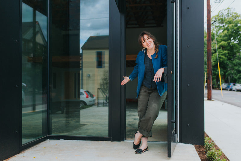 Betsy Cross in front of the new betsy & iya storefront