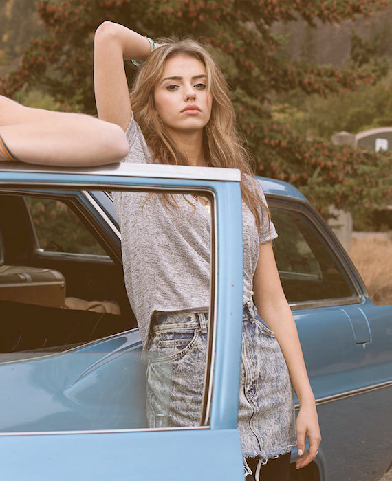 Model hanging outside of an antique car.