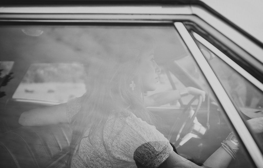 Black and white photograph of models in the car, old timey looking.