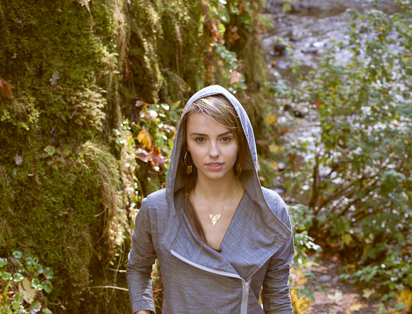 Model wearing betsy & iya jewelry in the woods.