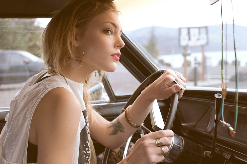 A model drives an antique car.