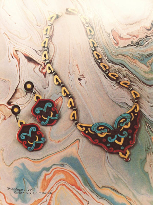 A colorful Mexican necklace and earrings lay side by side.