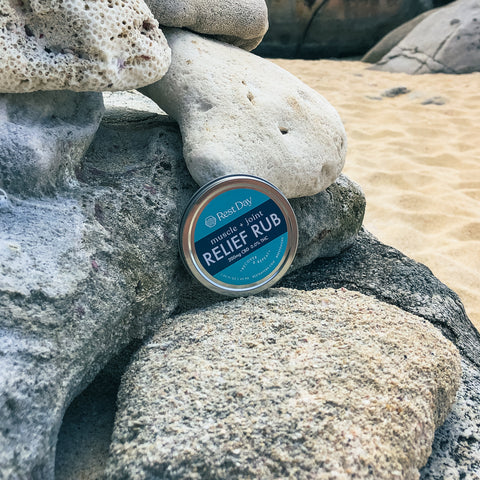 Muscle and Joint Relief Rub on rocks at the beach