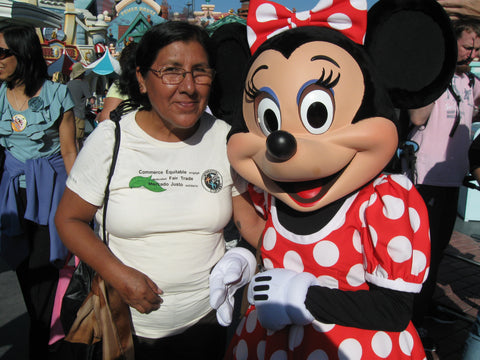 Our new board member Esperanza wearing a white t-shirt and standing next to Minnie Mouse.