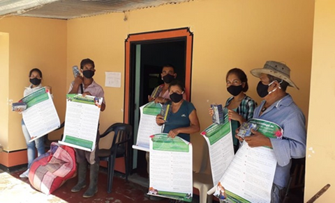 Colombian farmers holding COVID-19 safety signs