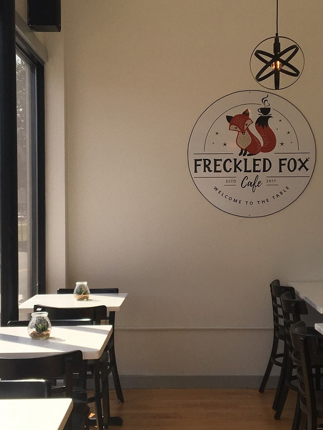The Freckled Fox cafe logo on wall