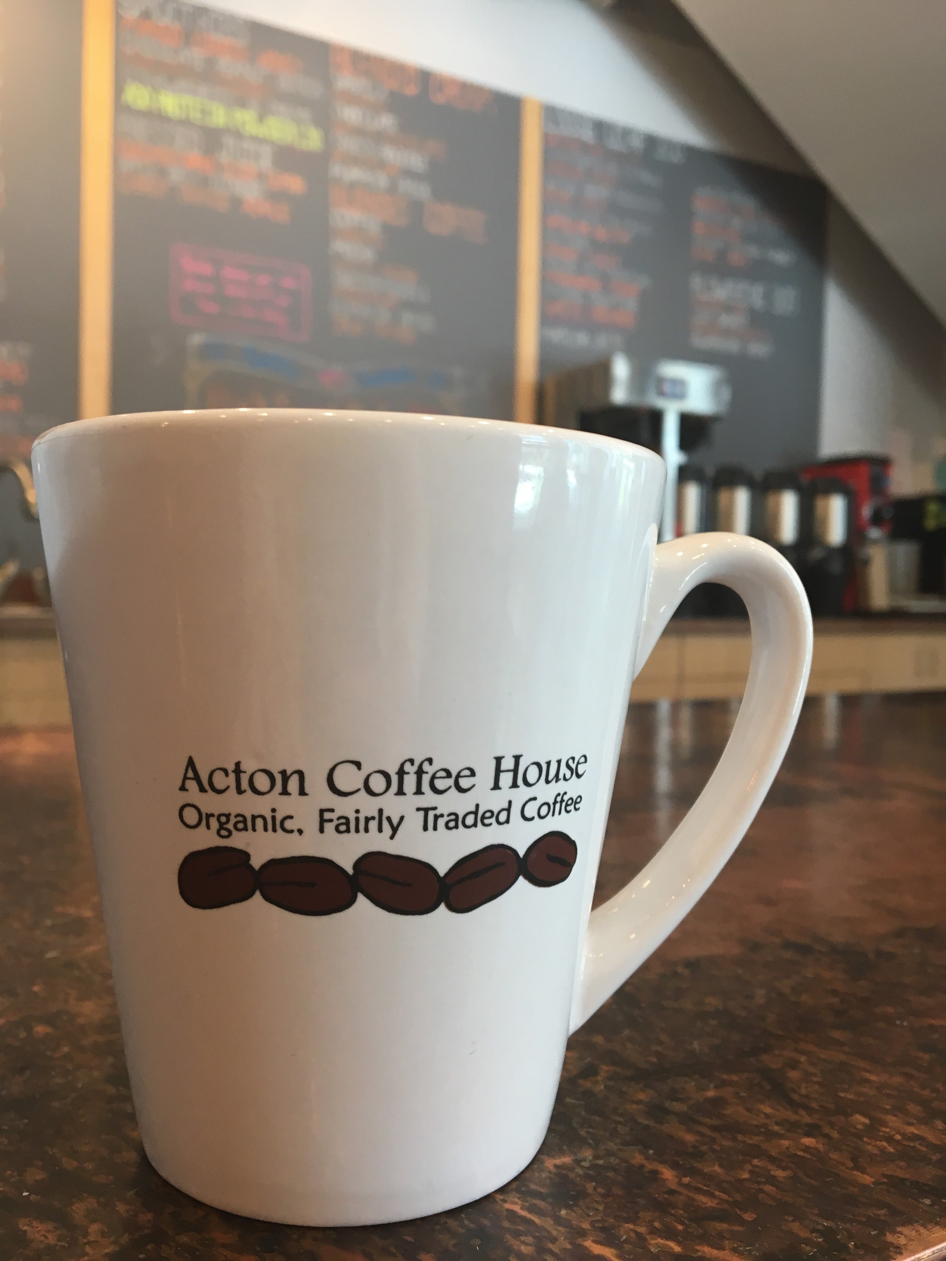 A coffee mug with the words "Acton Coffee House"