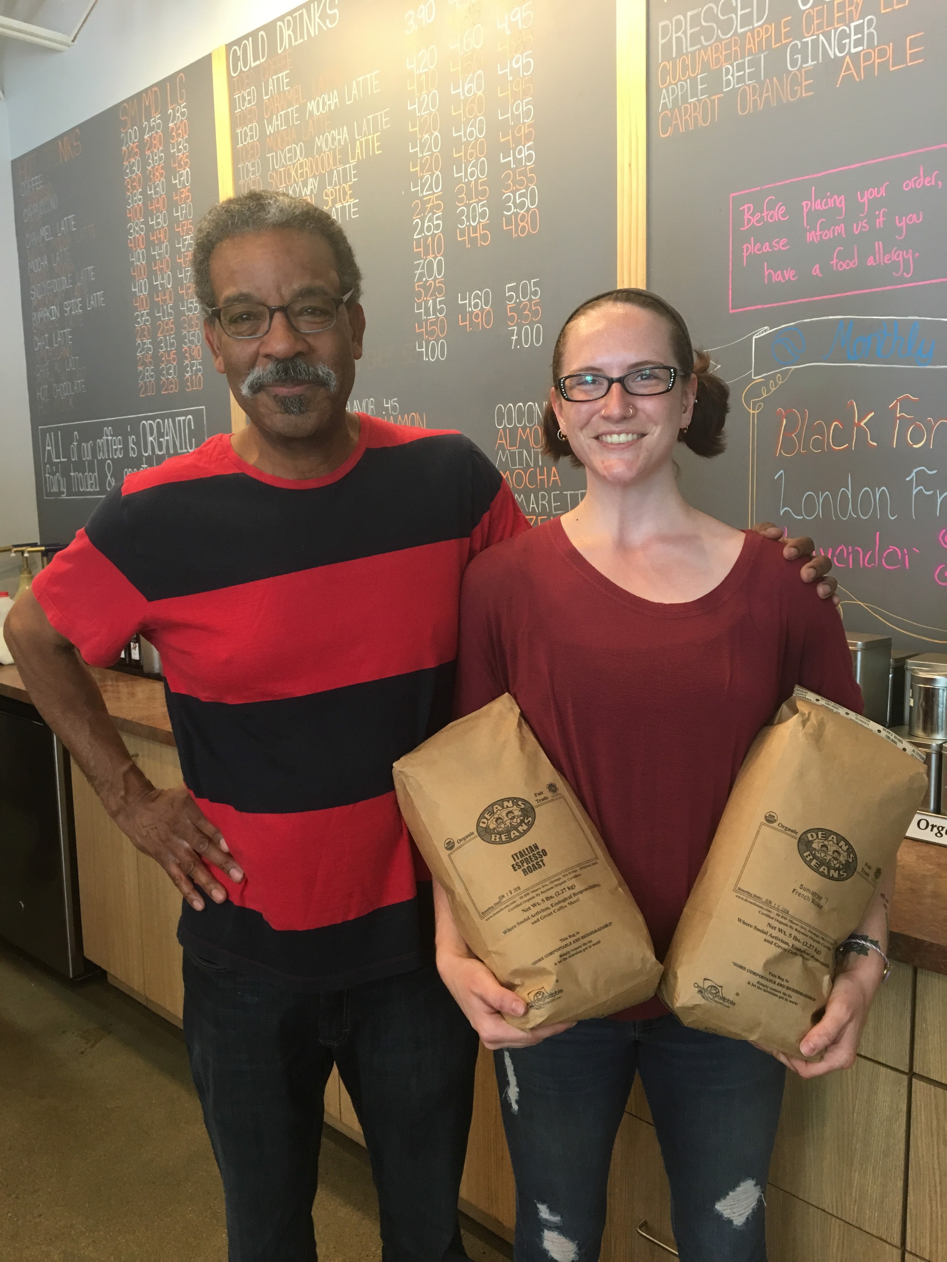 Owners of Acton Coffee House holding two bags of Dean's Beans coffee beans