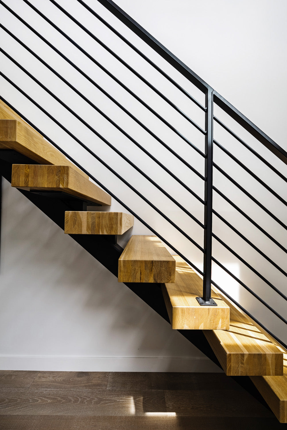 Wood stairs and metal railing by Edgework Creative