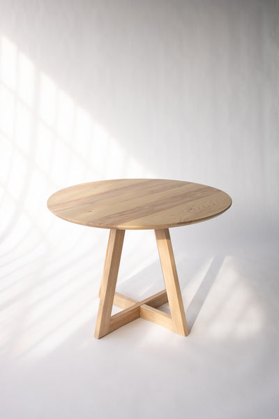 Round wood dining table by Edgework Creative