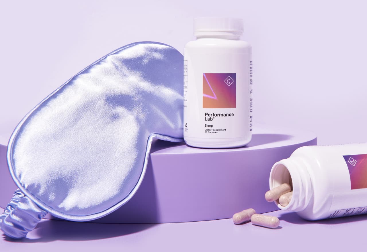 A Performance Lab® Sleep bottle next to a sleeping mask and pills