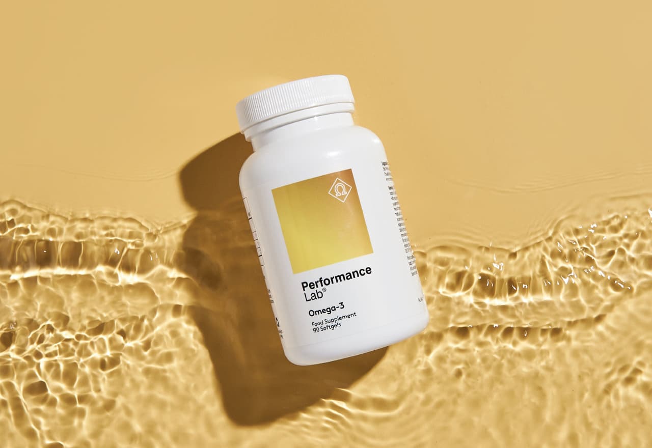 Performance Lab® Omega-3 bottle floating in water against a golden background.