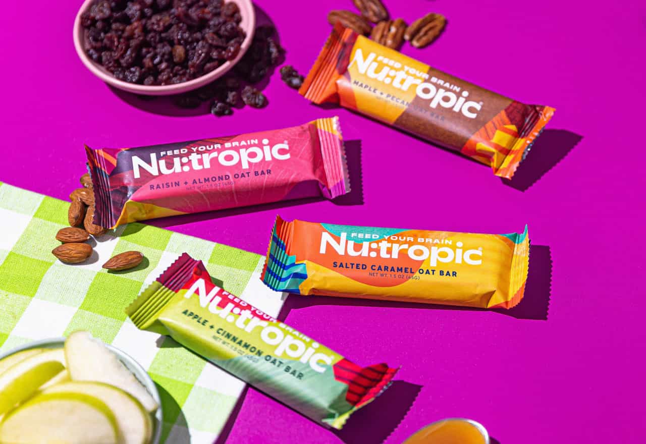 Nu:tropic bars: three flavors next to raisins, nuts and apple slices.