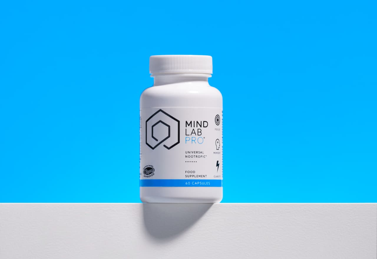 Best Choline Supplement: Mind Lab Pro®. White supplement bottle perched on a ledge against a blue background.