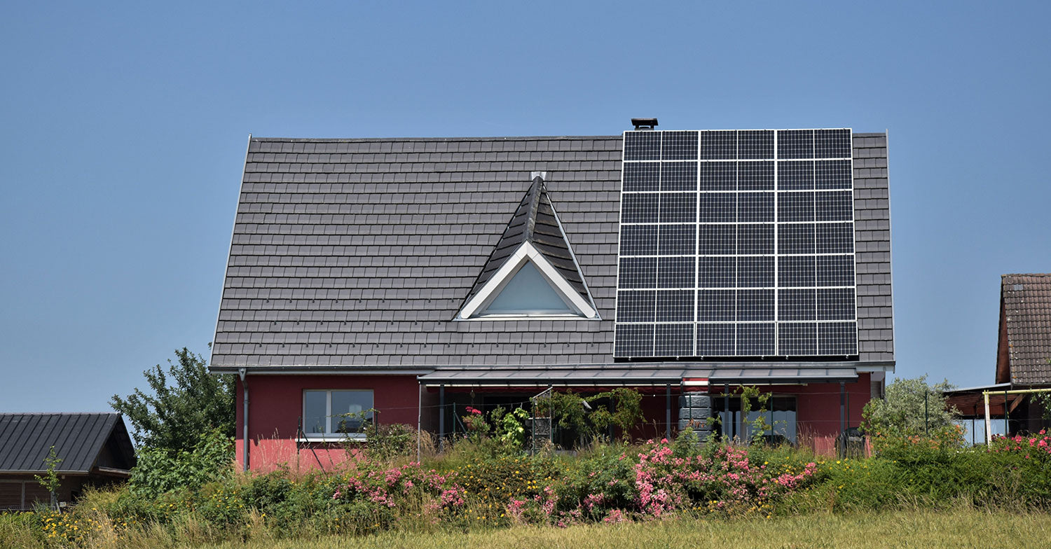 Sonnenkollektoren an einem Haus – Konzept zur Reduzierung des CO2-Fußabdrucks