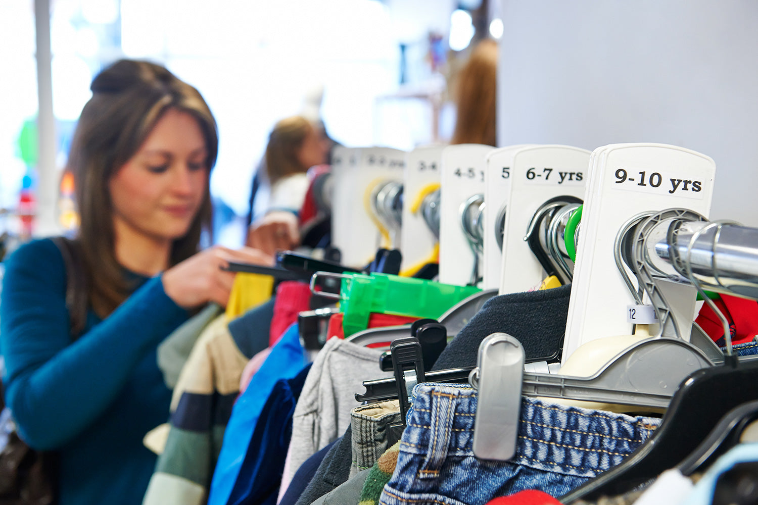 A Woman Buying Clothes for Kids at Thrift Stores