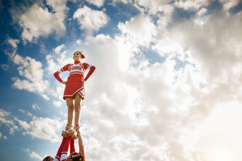 Cheerleader lyfts upp av cheerleaders