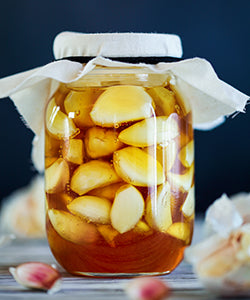 Pickled garlic cloves in a jar.