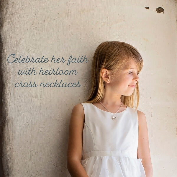 Little girl in white First Communion dress wearing silver cross necklace