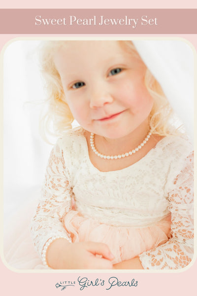 little girl wearing a lace dress and a sweet pearl necklace for girls.