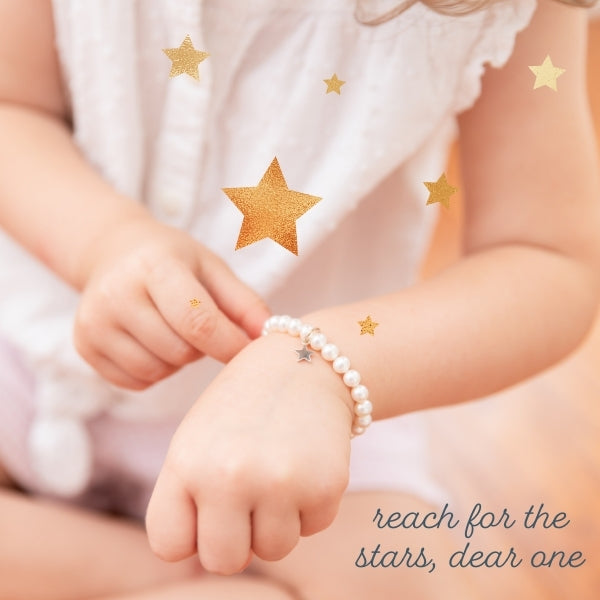 little girl with a pearl bracelet and a sterling silver star charm.