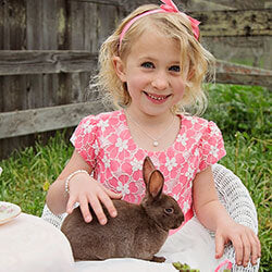 Little Girl holding a bunny and wearing a silver Easter necklace from Little Girl's Pearls.