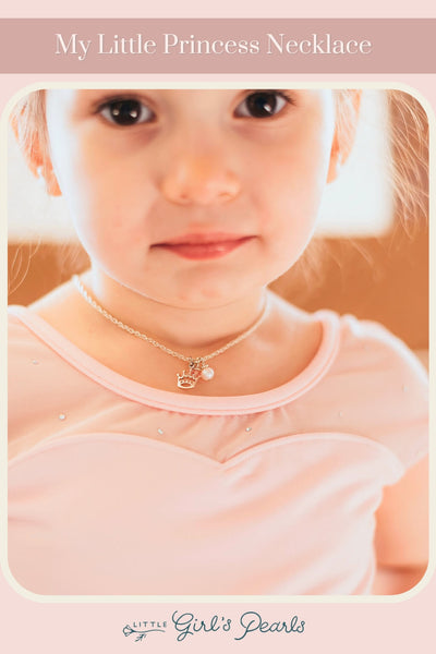 little ballerina toddler wearing a princess necklace with pearls.