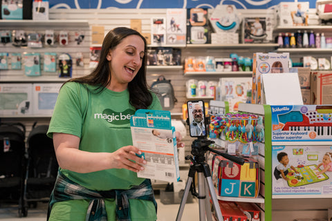 Mia showing someone baby gear at Magic Beans Wellesley