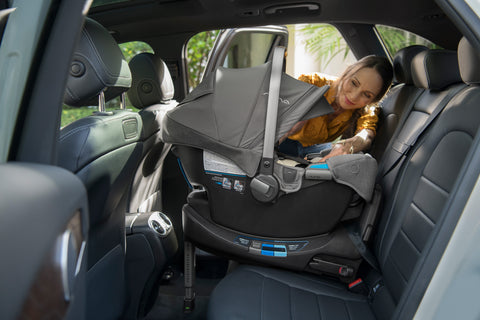 Woman interacting with baby in Pipa RX installed in center seat