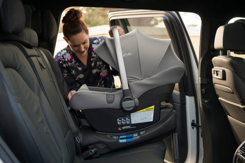 Woman putting Nuna Pipa Lite R in car