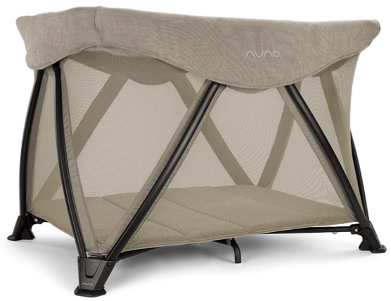 A nuna sena aire travel crib in beige sits on a studio white background