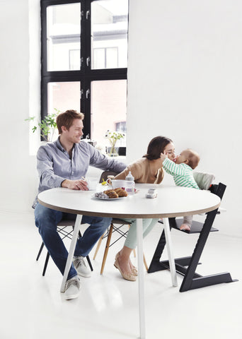 Man and woman interacting with baby in Tripp Trapp at the table