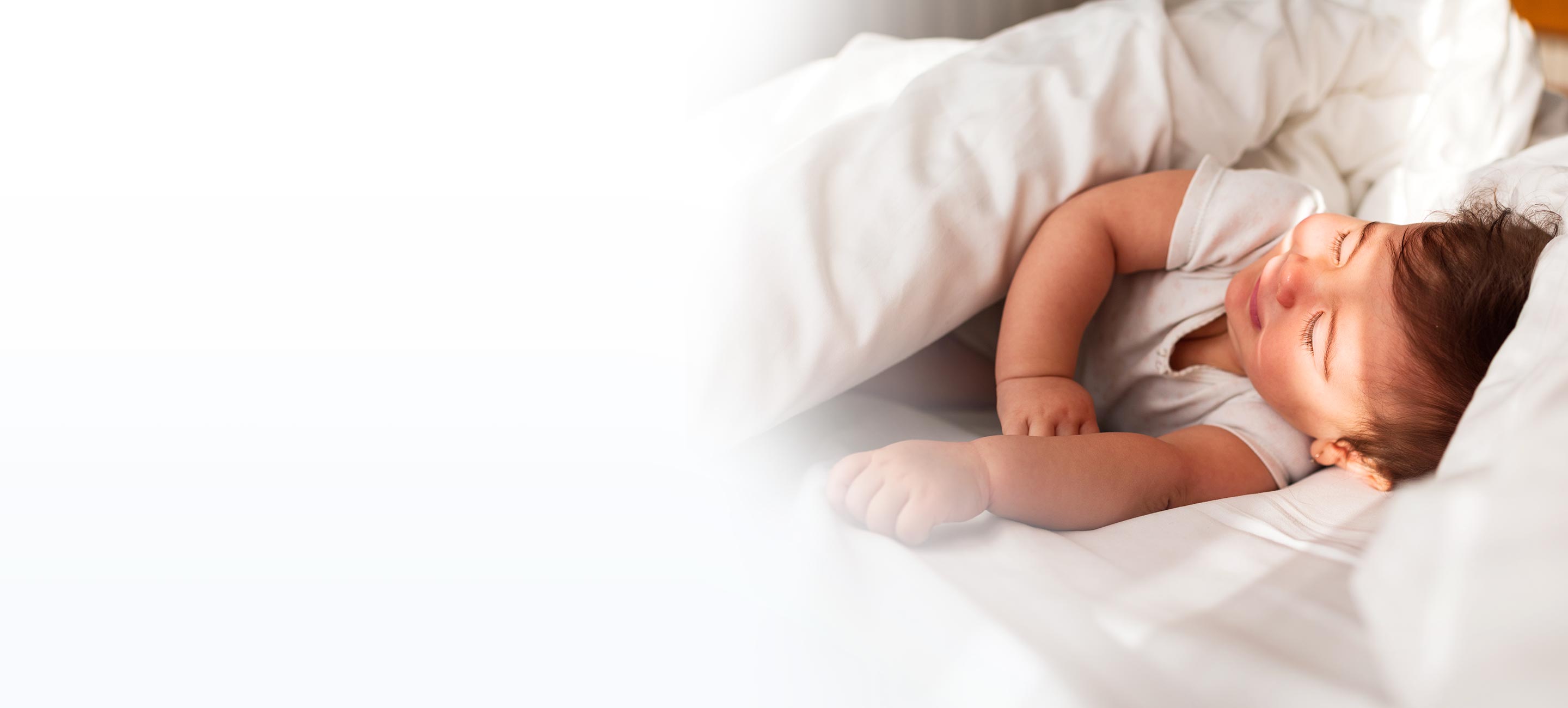 infant resting in bed