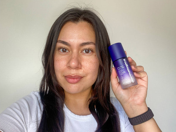 Alexis wearing a white t shirt holding a bottle of Dermalogica Phyto Nature Oxygen cream