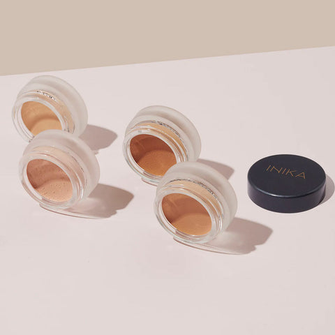 Four jars of INIKA full coverage concealer on their sides