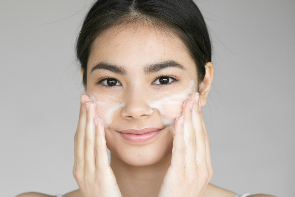 Young woman washing face with best facial cleansers