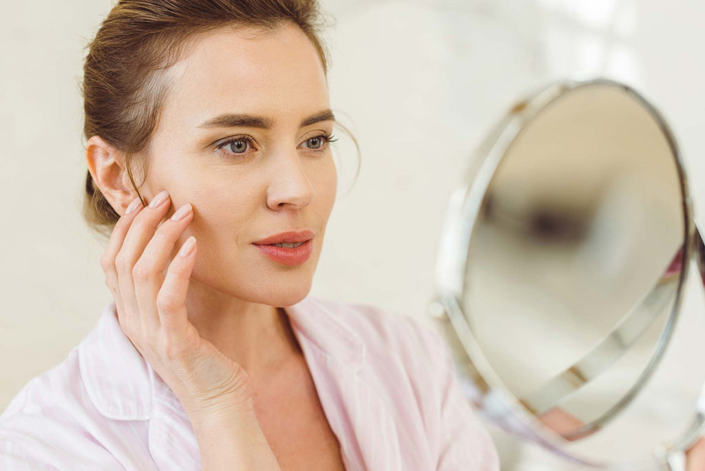 Woman examining pores in skin