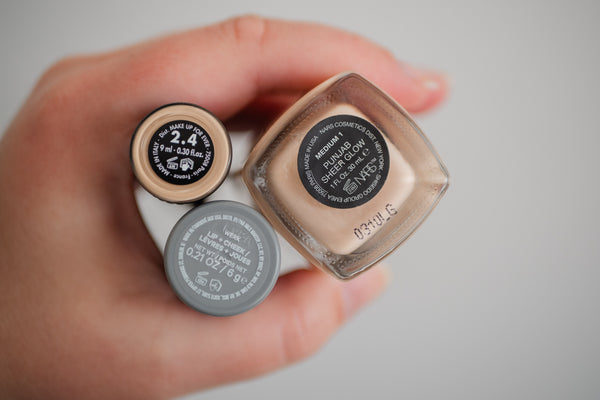 Woman holding makeup products to show expiry guidelines with PAO on bottom of packaging.