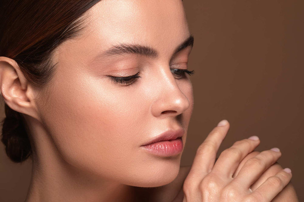 Woman with clear skin looking at her hand 