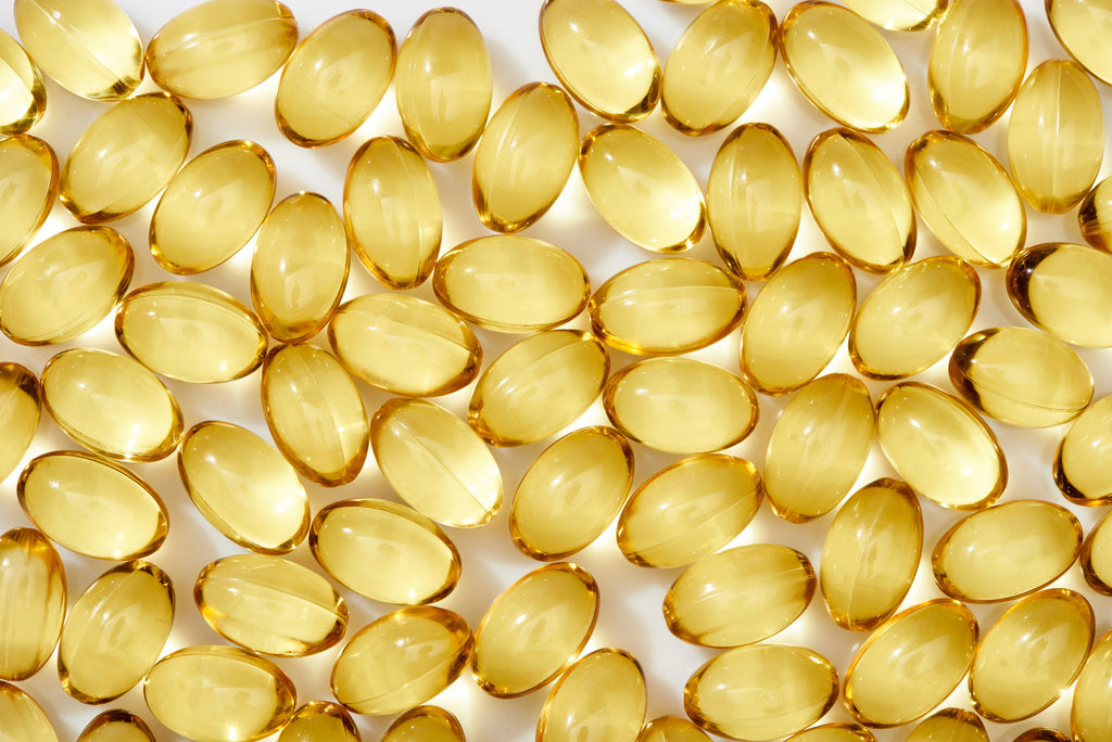 Vitamin E capsules on white background