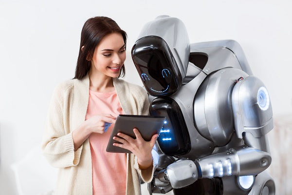 Photo of a beautiful girl holding tablet and showing it to the robot