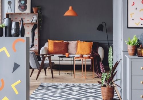 A bachelor pad painted in beautiful deep tones with many pop of color to brighten, and add fun to the space. Cool gray walls, with pops of orange, white, yellow, and burgundy.