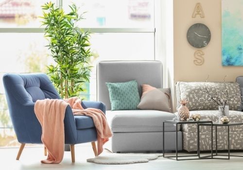 Living space with walls painted beige, and neutral tones accents. Small pops of soft timeless hues such as pink, blue, and green. A portrait of timeless colours used in the interior of a home or office space.